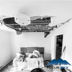A bedroom with a collapsed ceiling due to water damage, awaiting restoration by Clear Sky Restoration & Construction in Jackson, WY.