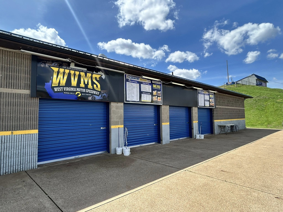 Commercial building with multiple blue roll-up garage doors installed by Overhead Door Company of Mid-Ohio Valley in Parkersburg, WV.