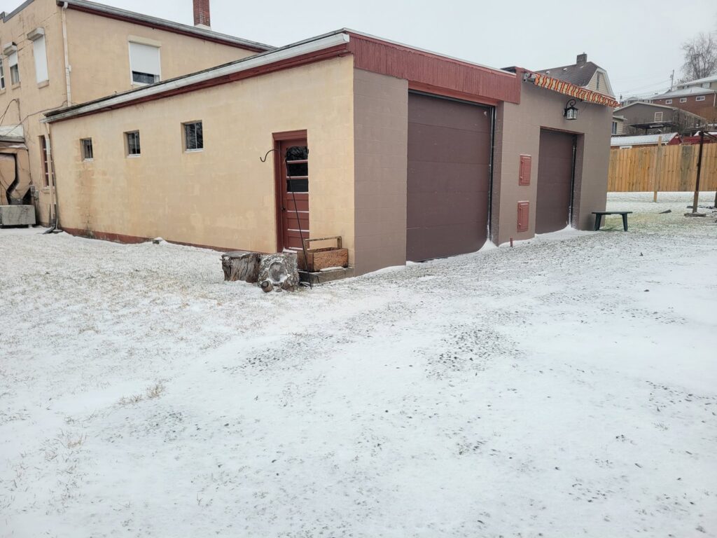 Commercial brown garage doors on a building in a snowy setting by Access Door Systems in Uniontown, PA.