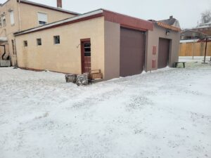 Commercial brown garage doors on a building in a snowy setting by Access Door Systems in Uniontown, PA.