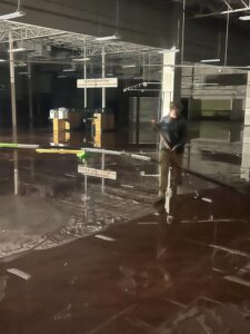 A large commercial building with significant standing water on the floor, indicating a water damage cleanup by SERVPRO of South Shreveport in Shreveport, LA.