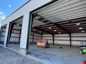 Exterior of a commercial building with three garage doors partially open, installed by Barrett Overhead Doors in Idaho Falls, ID.