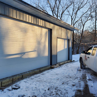 Commercial dark brown garage doors installed on a business by 74 Garage Door Company in Lake Park, FL
