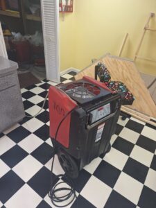 A commercial dehumidifier operating on a tiled floor for water damage drying by Flood Force in Dayton, OH.