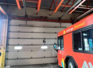 A large commercial garage door inside a bus depot, installed by NDI Garage Door in Plaistow, NH.
