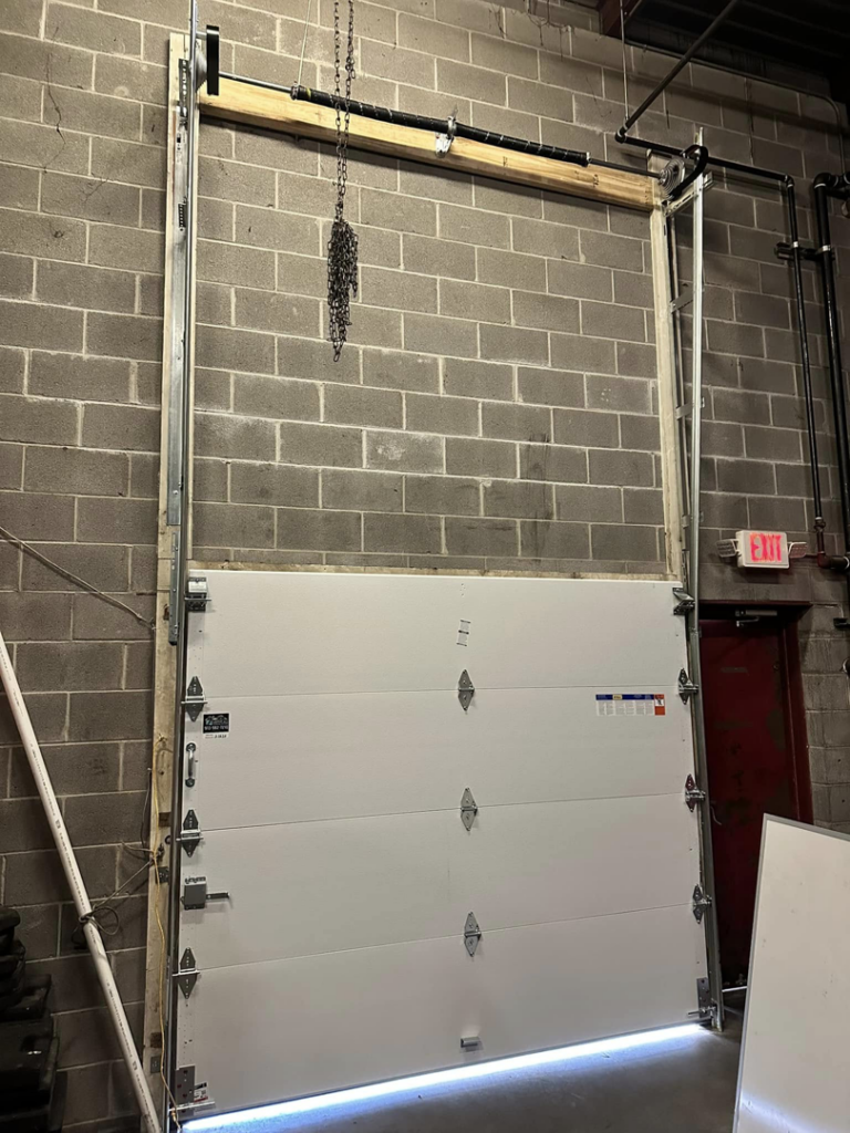Commercial garage door installation in progress by Above All Garage Doors in Kansas City, KS.