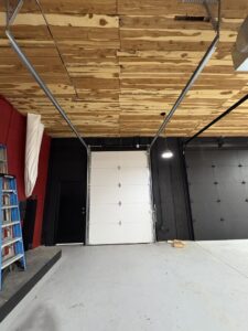 Interior view of a newly installed white commercial-style garage door by The Door Pros in Wichita, KS