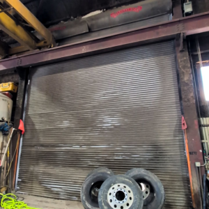 A commercial roll-up garage door in a busy workshop, serviced by Alaska Door in Wasilla, AK.