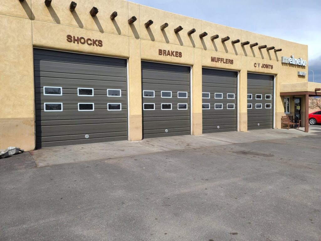Four commercial garage doors with windows installed on an auto service shop by Precision Garage Door of Albuquerque and Santa Fe, NM.
