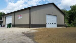 Two white commercial garage doors installed on a building by Cedar Valley Garage Doors in Waterloo, IA