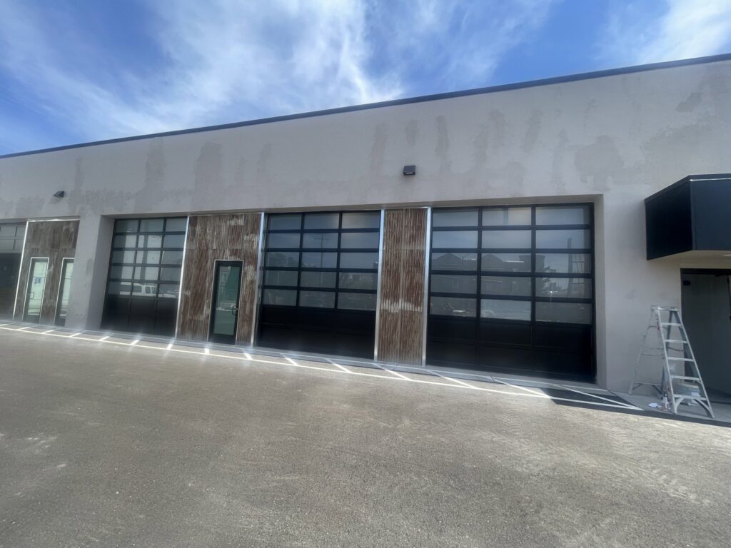 Commercial glass garage door installation with corrugated metal accents by Overhead Door of Sierra Nevada in Reno, NV.