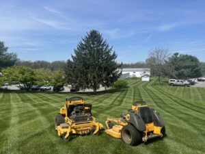 Two commercial riding lawn mowers parked on a large, perfectly striped lawn, ready for or after a job by Neace's Lawn Care LLC in Martinsburg, WV.