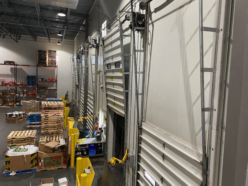Multiple commercial loading dock garage doors inside a warehouse, showcasing work by Right Choice Doors in Layton, UT.