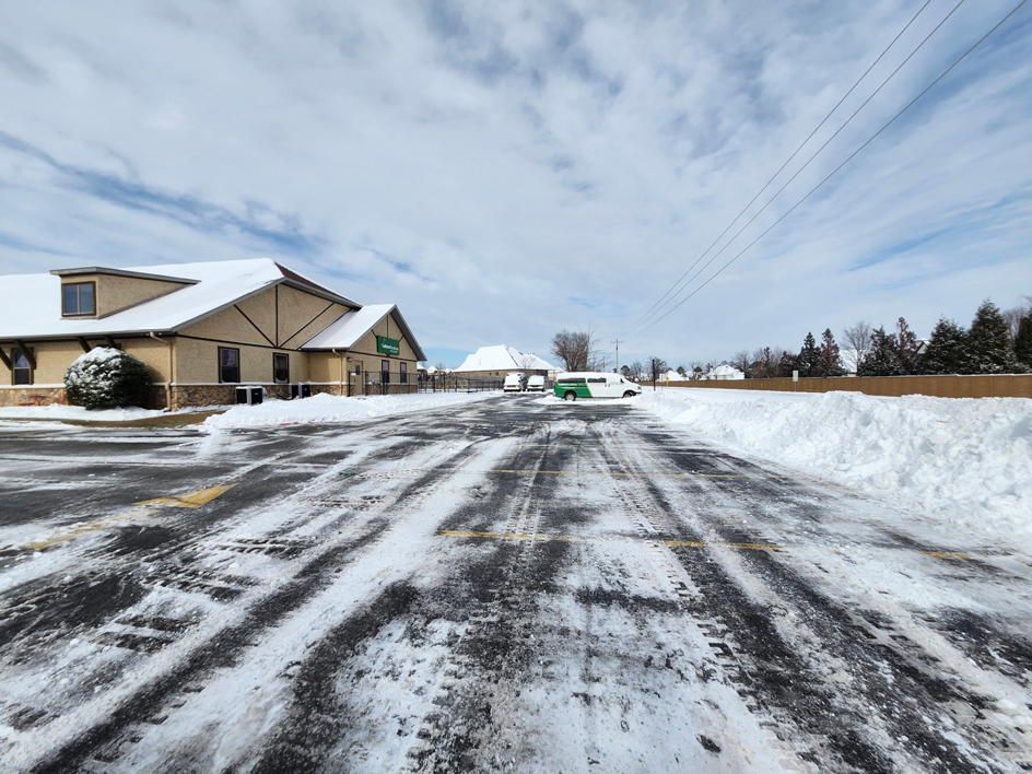 A large commercial parking lot after professional snow removal by Bridgewood Landscape in Rogers, AR.