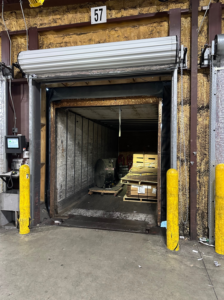 A commercial rolling overhead door above a loading dock, serviced by JTL Garage Doors in Fargo, ND.
