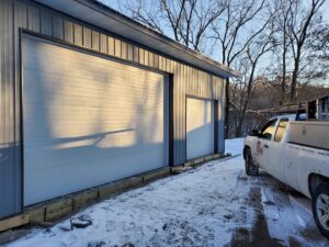 Commercial white garage doors installed on a building in winter by 74 Garage Door Company in Lake Park, FL