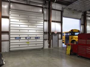 A large white sectional commercial garage door installed in a warehouse by Wayne Dalton Sales & Service of Quad Cities in Davenport, IA.
