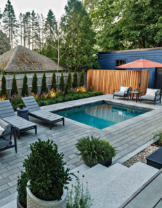 A compact modern inground pool surrounded by a paver patio and lounge chairs by Christman Pool Service in Portland, ME.