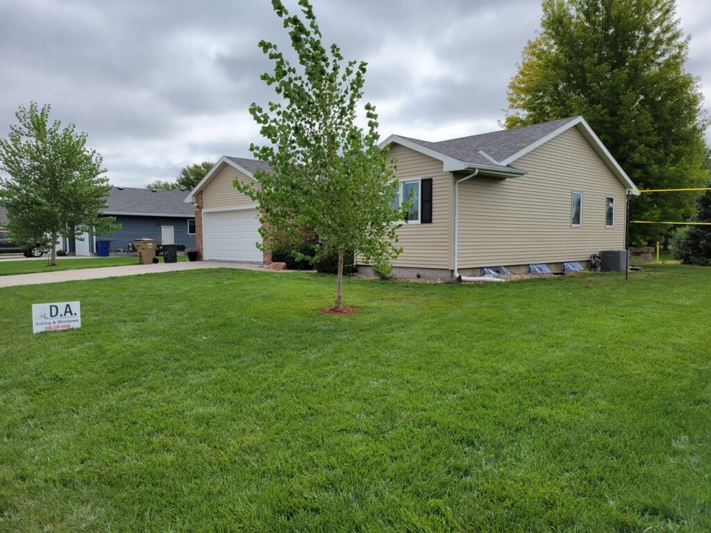 A completed beige horizontal siding project on a residential home by D.A. Siding & Windows in Grand Island, NE.