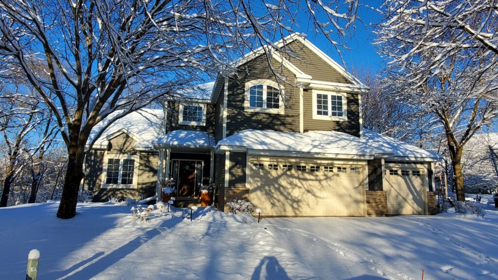 A house with newly installed dark gray siding, surrounded by snow in winter, completed by Archcraft Exteriors in South Saint Paul, MN.
