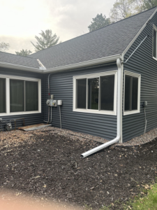 A completed dark gray vinyl siding installation on a house exterior by PMC Company in Brooklyn Park, MN.