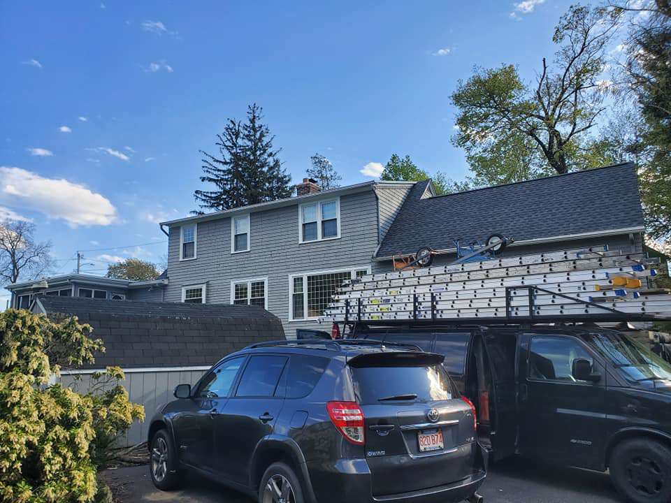 A beautifully completed gray siding job on a residential house by Trabajo en roofing y siding in Lowell, MA.