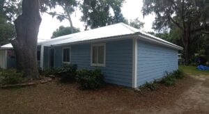 A house with newly completed light blue siding and a white metal roof by Action Roofing and Siding Co in South Saint Paul, MN