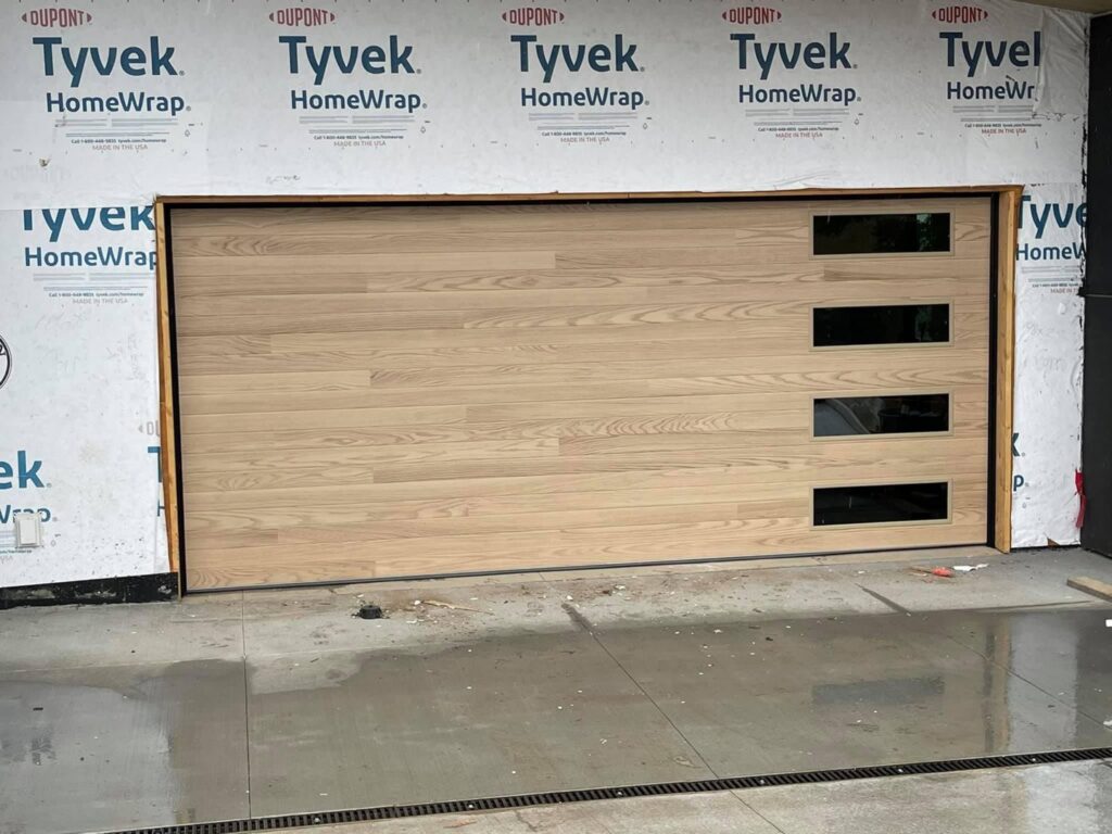 A completed modern wooden garage door with horizontal panels and windows, installed by NV Pro Garage Doors in Las Vegas, NV.