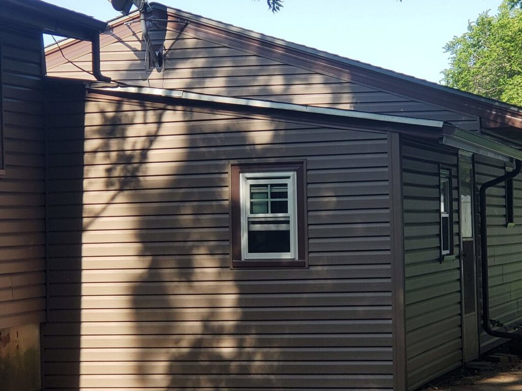 A completed siding project featuring new brown siding on a house by River City Exteriors in San Antonio, TX