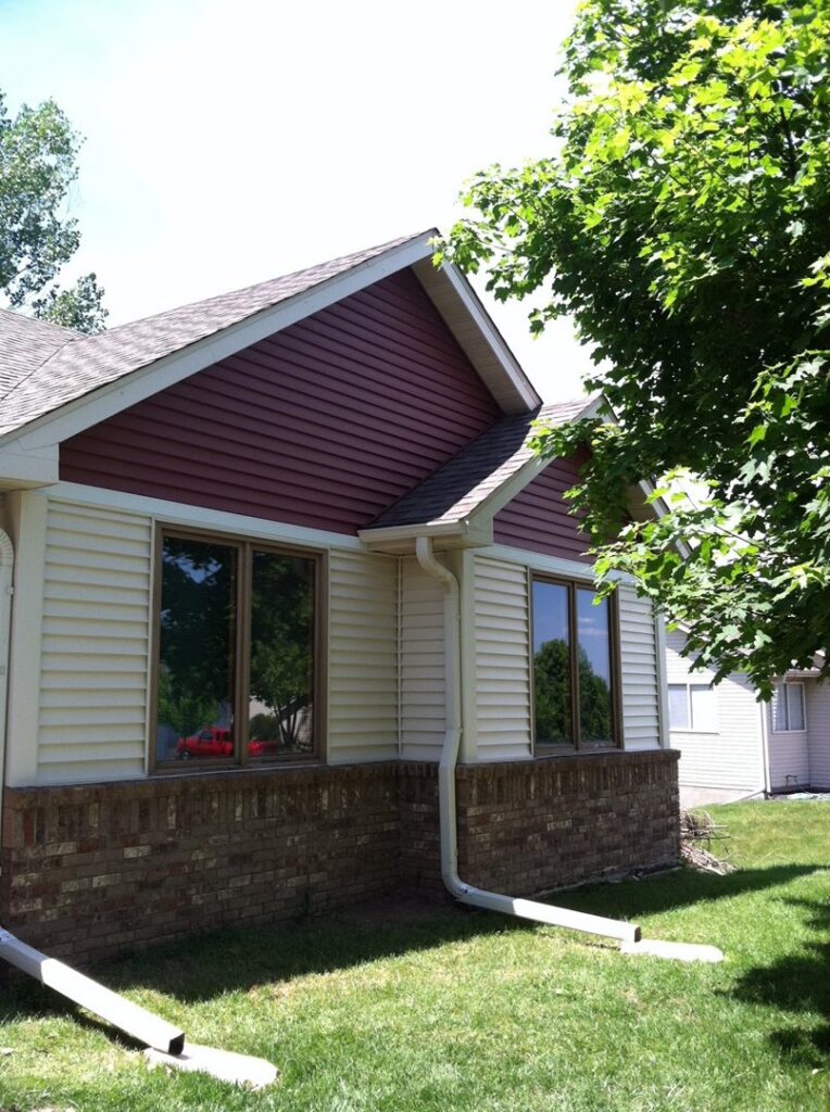Newly installed beige and red siding and new windows on a house by Capital Siding, Windows & Roofing, Woodbury, MN.