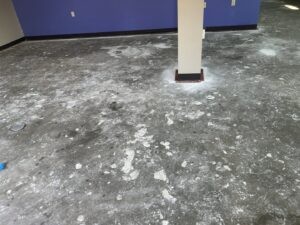 A concrete floor showing clear signs of water damage and stains, ready for remediation by Gold Star Services LLC in Newark, DE