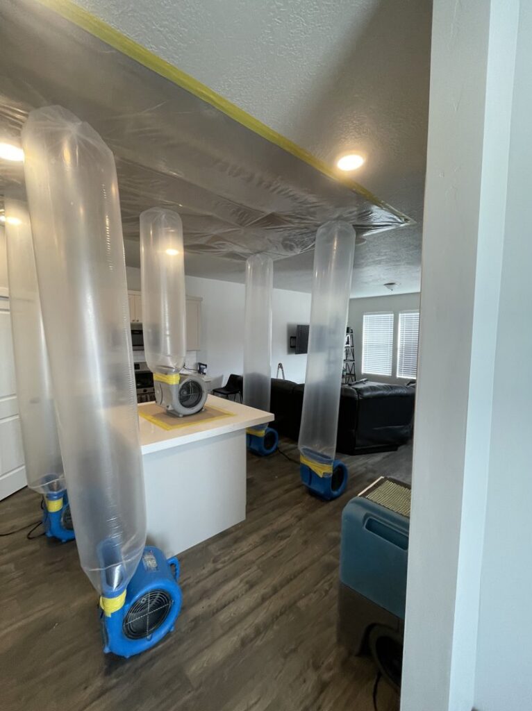 Plastic containment barriers and industrial drying equipment in a home, demonstrating professional water damage restoration techniques used by Standard Restoration in Salt Lake City, UT.