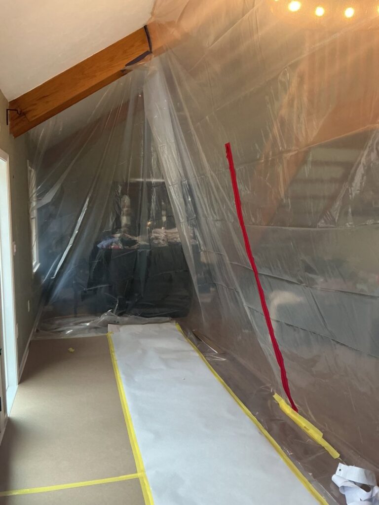 A containment area set up with plastic sheeting for water damage remediation by RestoPros in Norfolk County, MA.