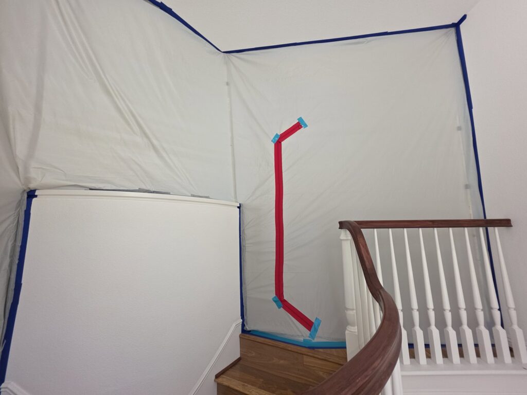 A containment barrier set up around a staircase for water damage remediation by Risk Free Serv Water Damage Repair San Diego, CA