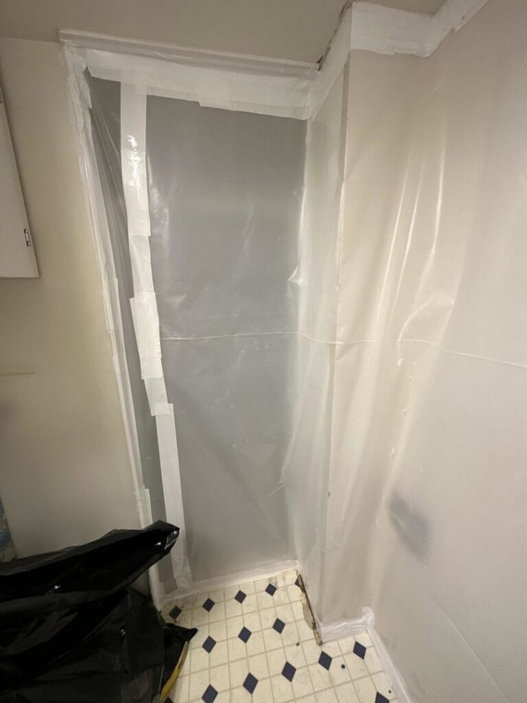A containment area set up with plastic sheeting for water damage remediation by APEX Restoration in Mililani, HI