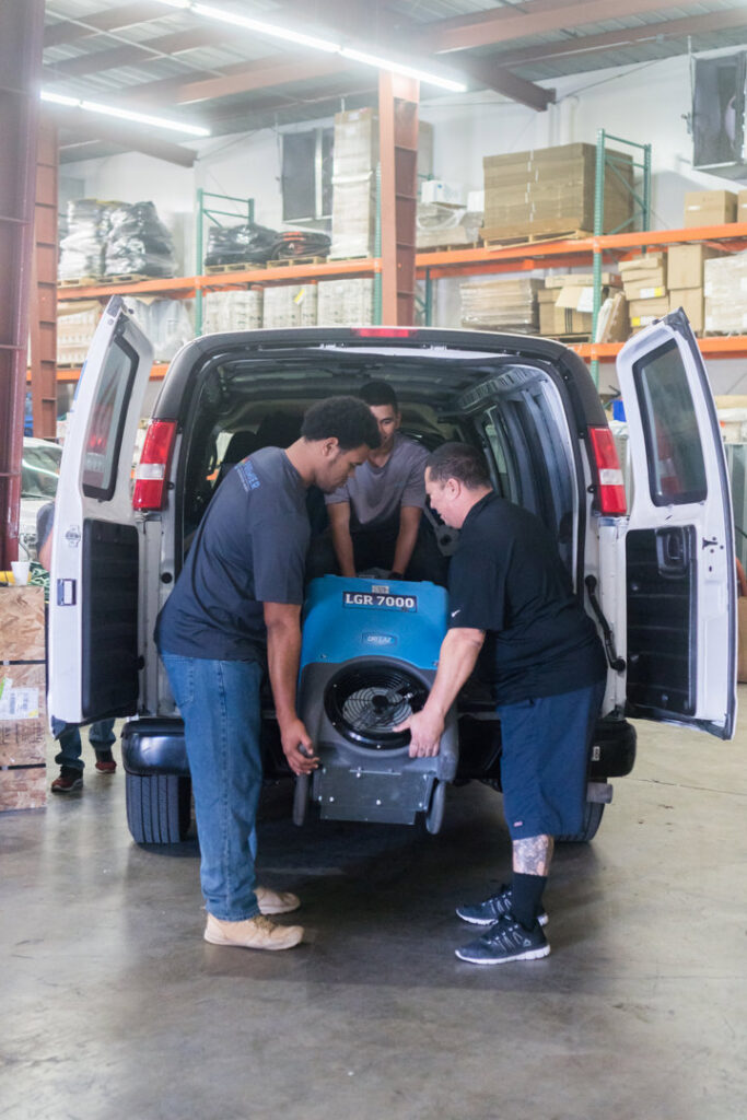 A water damage specialist setting up plastic containment barriers during a restoration job for Premier Restoration Hawaii in Honolulu, HI.