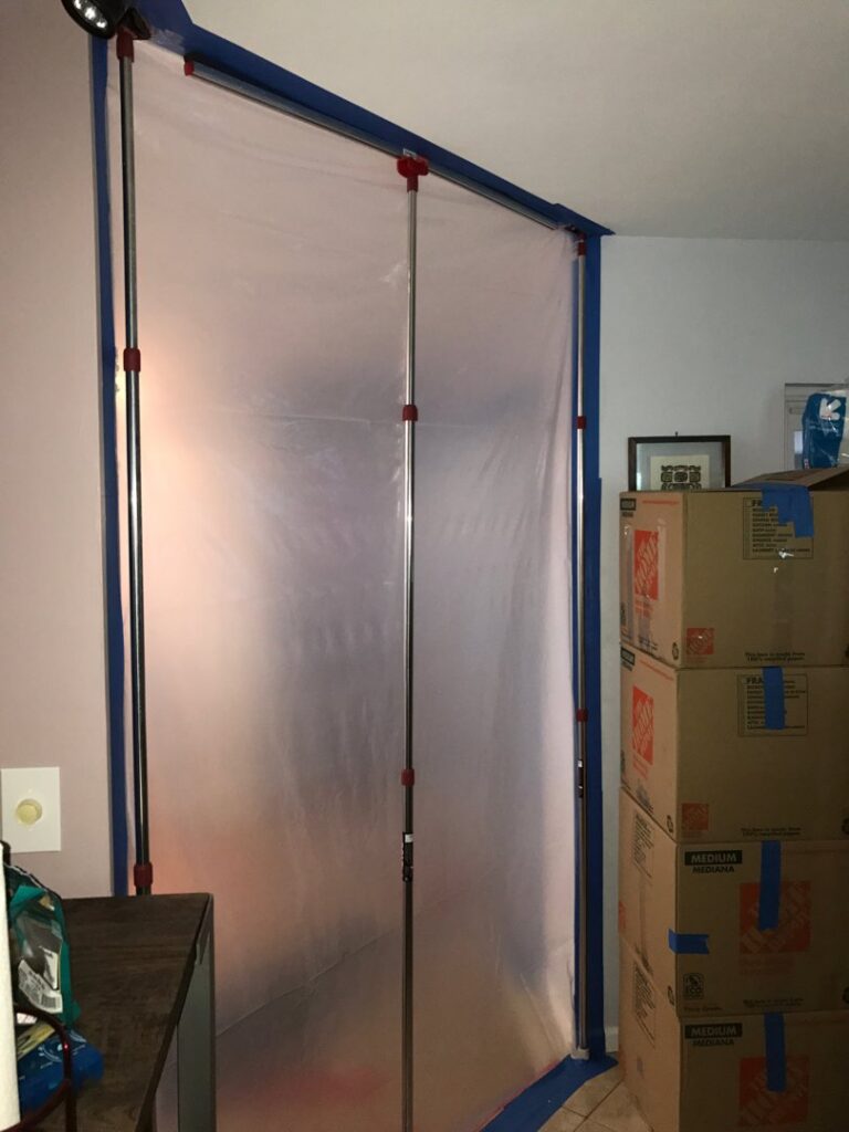 A containment area set up with plastic sheeting and tape for water damage restoration by Southcoast Cleaning Solutions & Restoration in Fall River, MA.