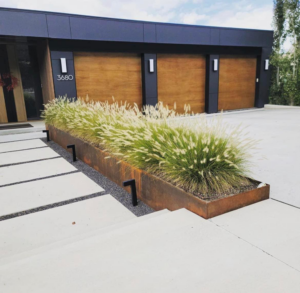 A contemporary home showcasing three elegant wood-look garage doors from Windsor Door Sales Inc. in Ogden, UT.