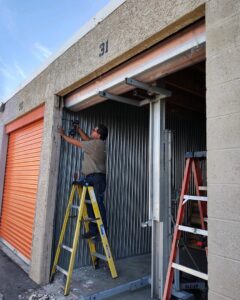 A contractor working on a roll-up storage unit door for Valley Overhead Door in Las Vegas, NV.