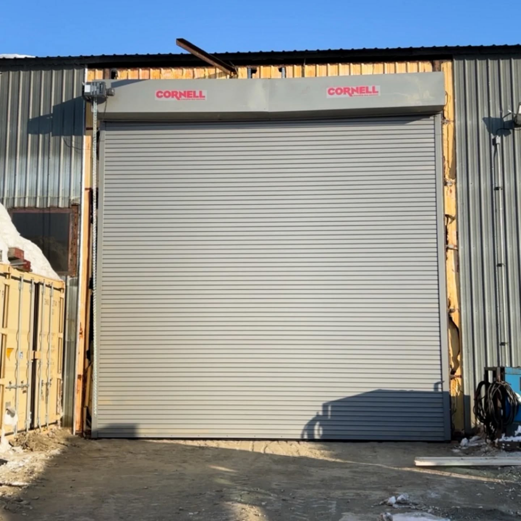 A Cornell commercial roll-up garage door installed by Alaska Door in Wasilla, AK, on a metal building.