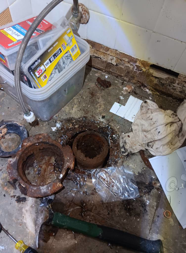 Severely corroded drain pipe being replaced during water damage remediation by Integrity Solutions in Omaha, NE.