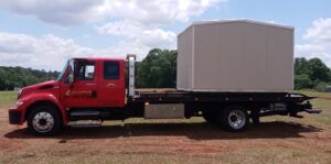 A covered container loaded onto a flatbed tow truck from Full Circle Towing and Recovery in Dothan, AL.