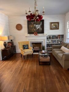 A cozy and clean living room with a decorative fireplace and hardwood floors, tidied by Top-Notch Tidy Services in Chesapeake, VA.