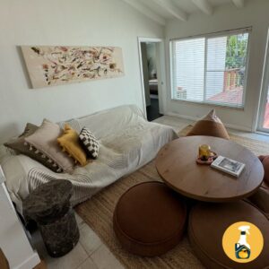 A cozy and clean living room with a sofa and round coffee table, tidied by The Prime Cleaner in Miami, FL.