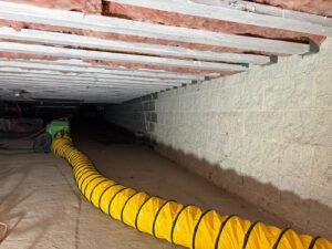 A crawl space being dried with large flexible ductwork for air movement by Mold Master Restoration in Jersey City, NJ