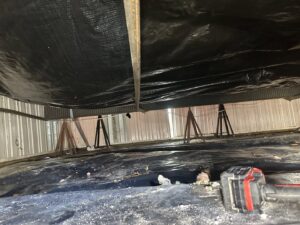 A crawl space with black plastic sheeting for encapsulation or moisture control by Brothers Restoration in Post Falls, ID.