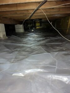 A crawl space with a newly installed vapor barrier for moisture control by New Method Restoration in Edison, NJ.