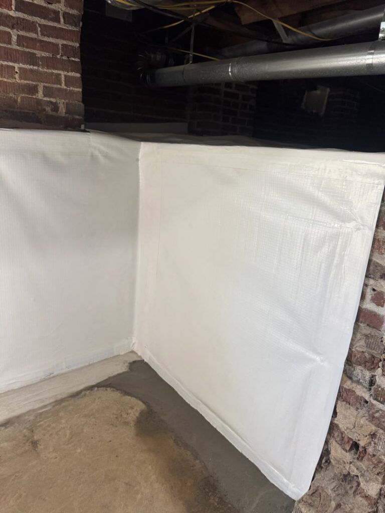 A crawl space wall covered with a white vapor barrier by Wetlock Waterproofing in Rock Hill, SC.