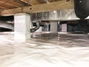 A crawl space with white vapor barrier showing standing water, addressed by Tidewater Home Improvement LLC in Hampton, VA.