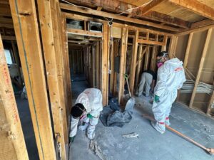 Servpro of Sandy crew in protective suits demolishing a damaged interior, likely after water damage, in Sandy, UT.